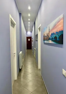 a hallway with blue walls and a painting on the wall at Oasi del Turista in Palermo