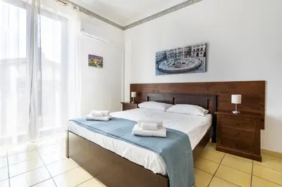 a bedroom with a large bed with two towels on it at Porta Carini Residence in Palermo