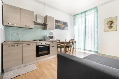 a kitchen with wooden cabinets and a table with chairs at Porta Carini Residence in Palermo