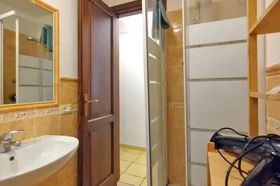 a bathroom with a sink and a glass shower door at Porta Carini Residence in Palermo