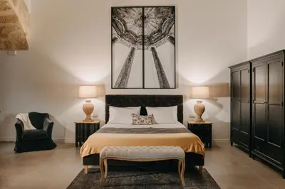 a bedroom with a bed and two lamps and a chair at Palazzo Natoli Boutique Hotel in Palermo