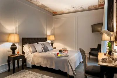 a bedroom with a bed with a tray of food on it at Palazzo Natoli Boutique Hotel in Palermo