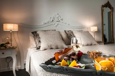 a tray of food and a glass of wine on a bed at Palazzo Natoli Boutique Hotel in Palermo