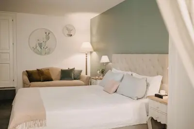 a bedroom with a white bed and a couch at Palazzo Natoli Boutique Hotel in Palermo