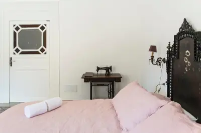 a bedroom with a bed and a desk and a door at B&B Malvasia in Palermo