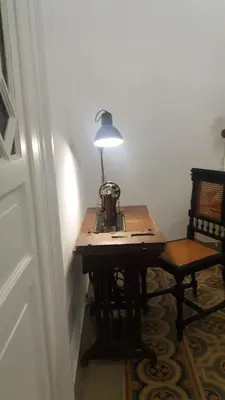 a table with a lamp on it next to a chair at B&B Malvasia in Palermo