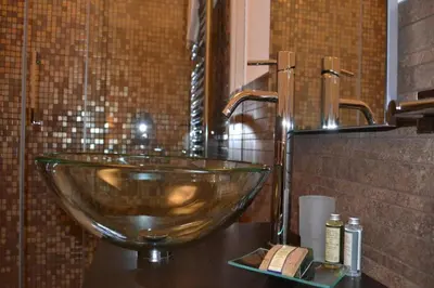 a bathroom with a glass bowl sink on a counter at Palazzo Ducale Suites in Monreale