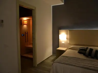 a bedroom with a bed and a hallway with a bathroom at Palazzo Ducale Suites in Monreale