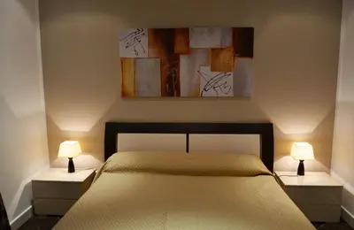 a bedroom with a bed and two night stands with lamps at Palazzo Ducale Suites in Monreale