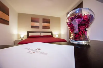 a vase of flowers sitting on a table with a bed at Palazzo Ducale Suites in Monreale