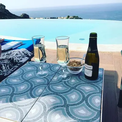 a table with two glasses and a bottle of wine at Hotel Antica Cascina Del Golfo in Scopello