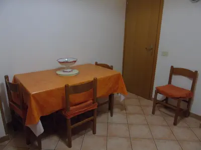 a dining room table and chairs with a bowl on it at Appartamento Marconi 15 in San Vito lo Capo