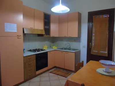 a kitchen with wooden cabinets and a stove top oven at Appartamento Marconi 15 in San Vito lo Capo