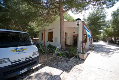 a van parked in front of a house with bikes at Camping Village La Pineta in San Vito lo Capo