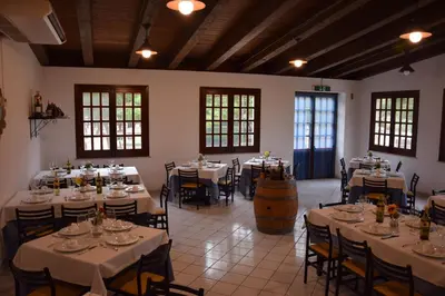 a large room with tables and chairs and a barrel at Camping Village La Pineta in San Vito lo Capo