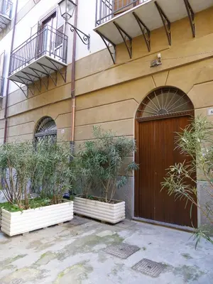 a building with a wooden door and some plants at Appartamento Moderno alla Cala by Wonderful Italy in Palermo