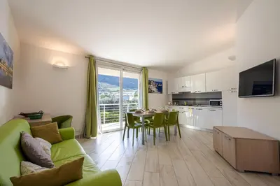 a living room with a green couch and a table at Borgo Aranci - Villetta a schiera Lavanda - A8 in Castellammare del Golfo