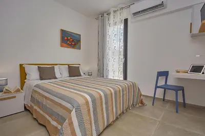 a bedroom with a bed and a desk and a table at Villa Vo' Scurá in Alcamo Marina