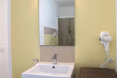 a bathroom with a sink and a hair dryer at Borgo Aranci - Villa Tulipano in Castellammare del Golfo