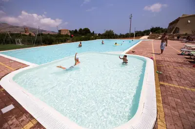 a group of people swimming in a swimming pool at Borgo Aranci - Villa Tulipano in Castellammare del Golfo