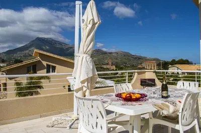 a white table with a bowl of fruit on a balcony at Borgo Aranci - Villa Tulipano in Castellammare del Golfo