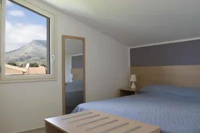 a bedroom with a bed and a large window at Borgo Aranci - Villa Tulipano in Castellammare del Golfo