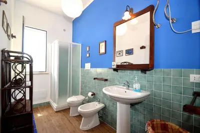 a bathroom with a sink and a toilet and a mirror at Villa Calamazzo in Scopello