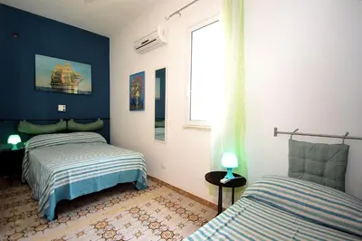 a bedroom with two beds and a window at Villa Calamazzo in Scopello