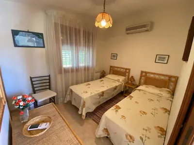 a bedroom with two beds and a table at Villa Paloma in Castellammare del Golfo