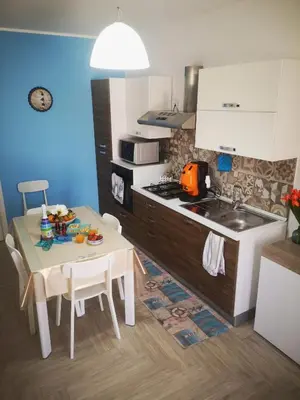 a kitchen with a table and a small kitchen with a sink at Il Faro Casa Vacanze Design Privacy Comfort e Posto Auto in San Vito lo Capo