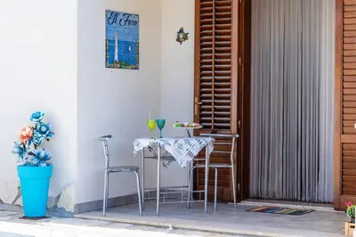 a table and chairs on the porch of a house at Il Faro Casa Vacanze Design Privacy Comfort e Posto Auto in San Vito lo Capo