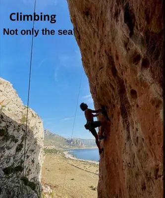 a man on a cliff climbing not only thesea at Il Faro Casa Vacanze Design Privacy Comfort e Posto Auto in San Vito lo Capo