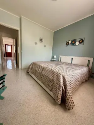 a bedroom with a bed with a blanket on it at Yucca Apartment in San Vito lo Capo