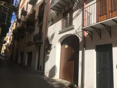 an alley with a building with a wooden door at Discesa Delle Capre Studio Confort in Palermo