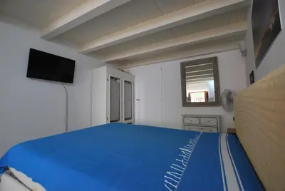 a bedroom with a blue bed and a television at Discesa Delle Capre Studio Confort in Palermo
