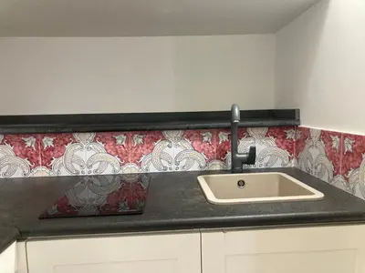 a kitchen counter with a sink and red and white wallpaper at Discesa Delle Capre Studio Confort in Palermo