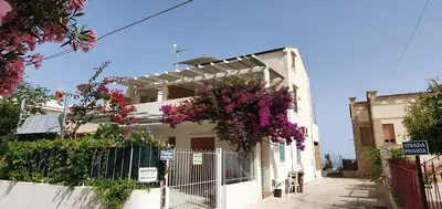 a white house with flowers on the side of it at Elios casevacanze sulla spiaggia in Alcamo