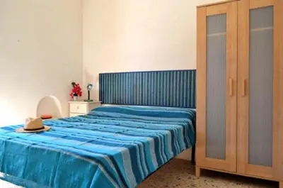 a bedroom with a bed with a blue comforter at Elios casevacanze sulla spiaggia in Alcamo