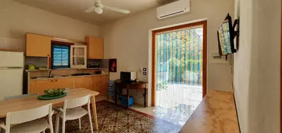 a kitchen and dining room with a table and a window at Elios casevacanze sulla spiaggia in Alcamo