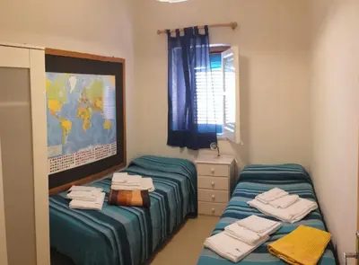 a room with two beds and a map on the wall at Elios casevacanze sulla spiaggia in Alcamo