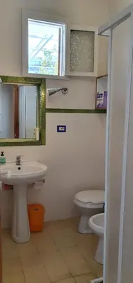 a bathroom with a sink and a toilet and a window at Elios casevacanze sulla spiaggia in Alcamo