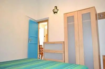 a bedroom with a bed and a blue door at Elios casevacanze sulla spiaggia in Alcamo