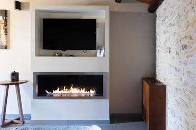 a living room with a fireplace with a tv above it at Tenute Baglio Passofondo in Alcamo