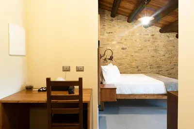 a bedroom with a bed and a desk and a table at Tenute Baglio Passofondo in Alcamo