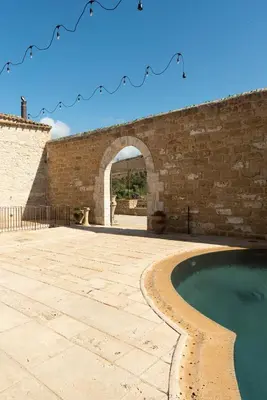 an external view of a building with a swimming pool at Tenute Baglio Passofondo in Alcamo