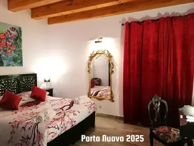 a bedroom with a bed and a mirror and red curtains at Casa Busari in Palermo