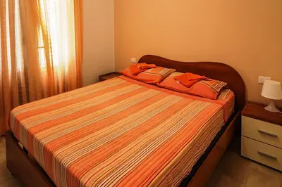 a bedroom with a bed with orange sheets and orange pillows at CASA 