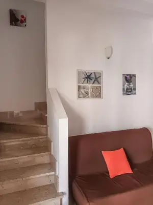 a living room with a brown couch with a red pillow at CASA 