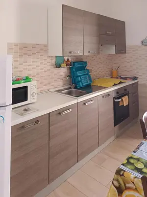 a kitchen with wooden cabinets and a sink and a microwave at CASA 
