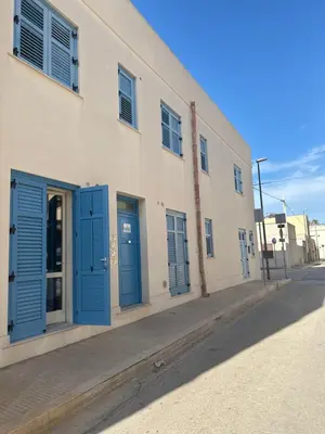 a building with blue doors on a street at appartamento residence via giardini Acquamarina in San Vito lo Capo